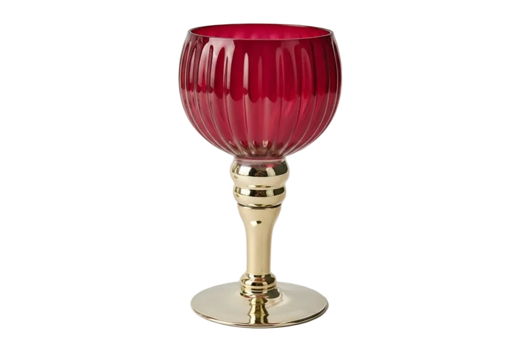 Gold candle holder with a red glass base on a white background