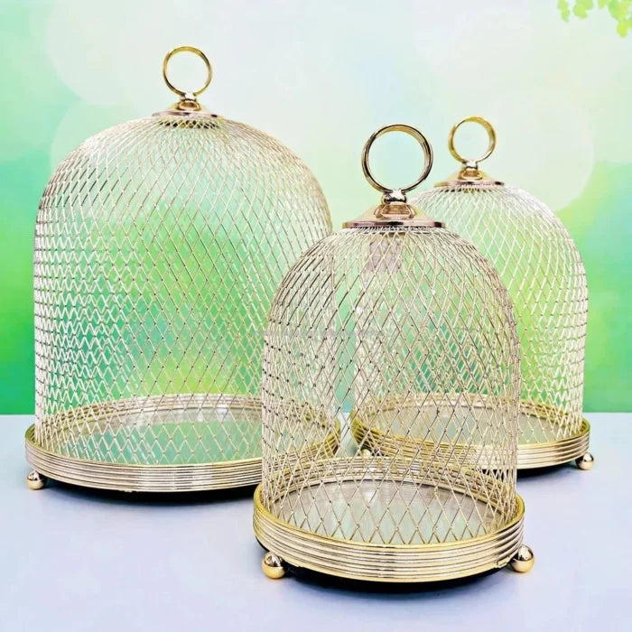 Set of three gold mesh domes on a light blue background