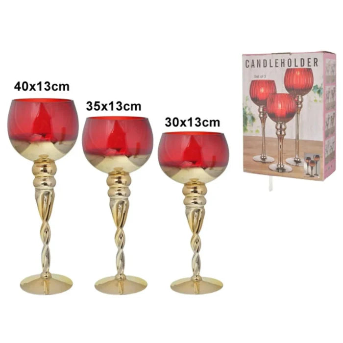 Three red candle holders with gold bases and a packaging box in the background.