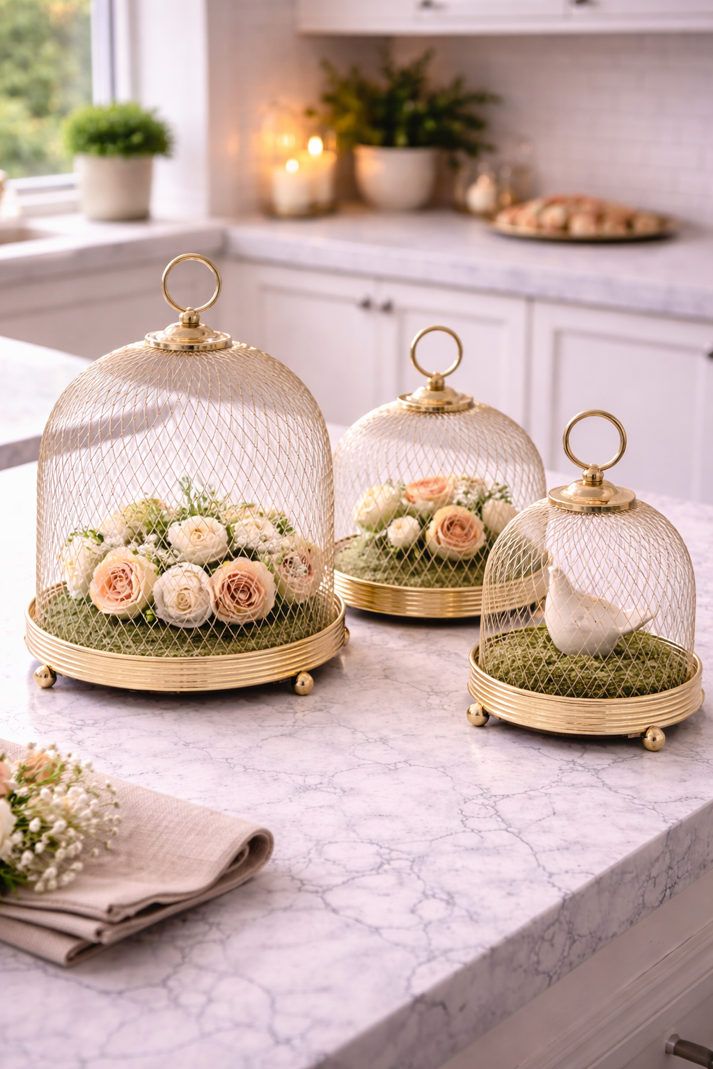 Decorative glass cloches with flowers and a bird on a kitchen counter.